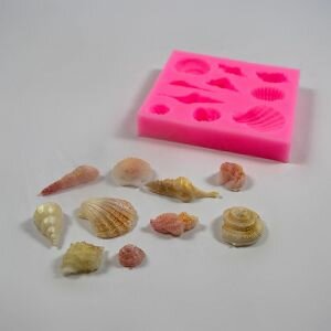 Small seashells silicone mould shown next to soap made using the mould