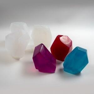 The gemstone silicone moulds shown next to soaps made using the moulds. 